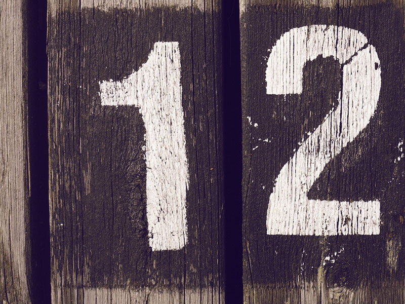 The number 1 and the number 2 painted on two boards, but put next to each other so it looks like 12.