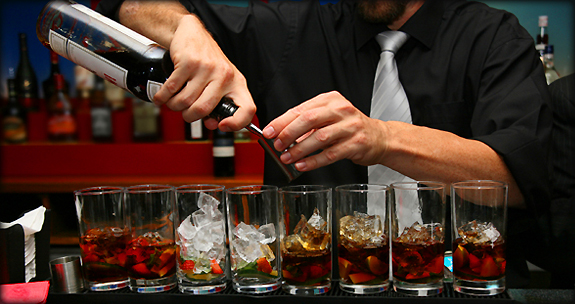 Boozing it up. Eight tumblers filled with cocktails.