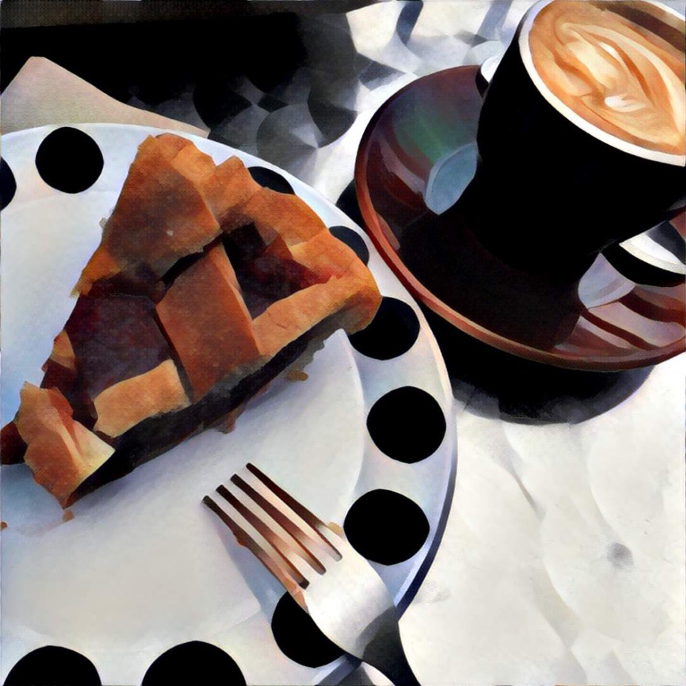 pie and a flat white coffee. the pie is on a cute white plate with big black polka dots around the rim. The table is hammered metal. It was windy. Oh, and there's also a fork.