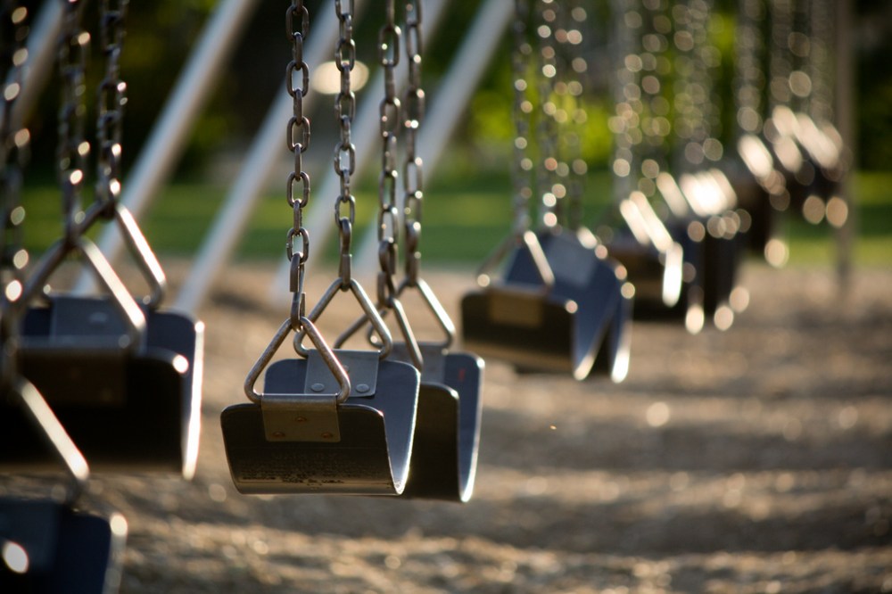 Empty swings in the schoolyard. At least it's a sunny morning.