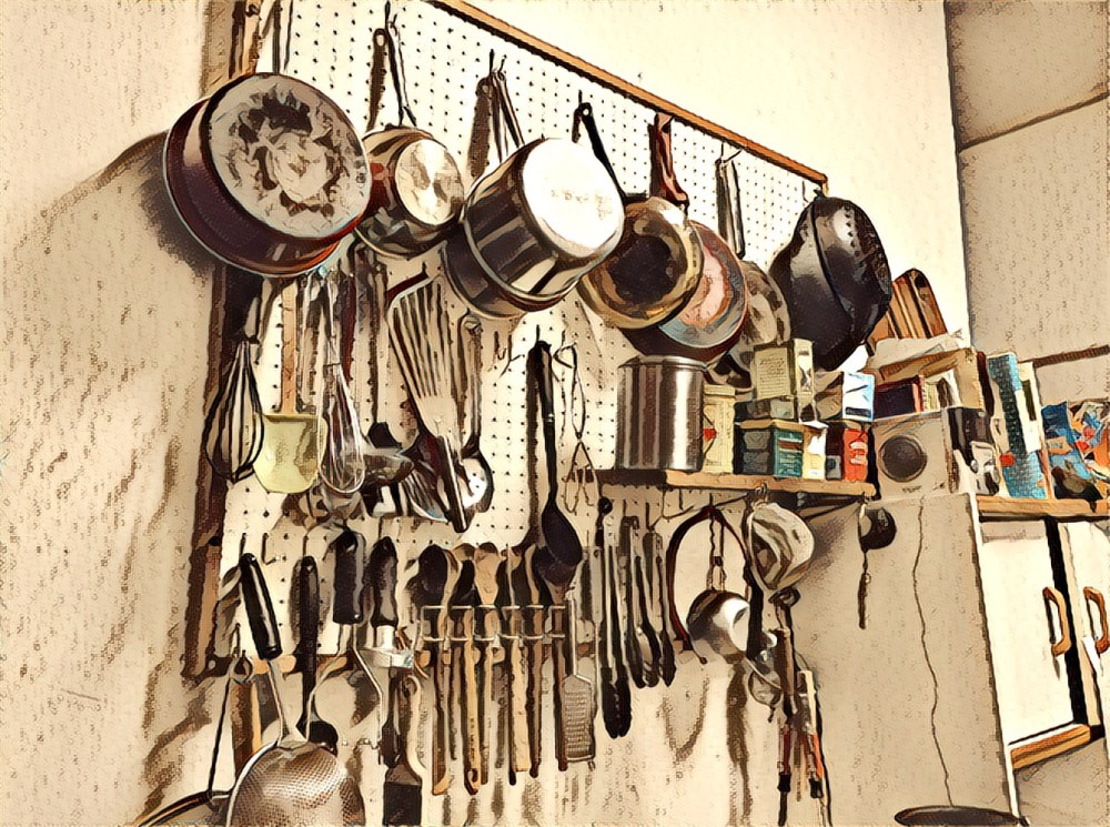 The wall of pots in our kitchen, hanging haphazardly on a pegboard wall. Circa now. 