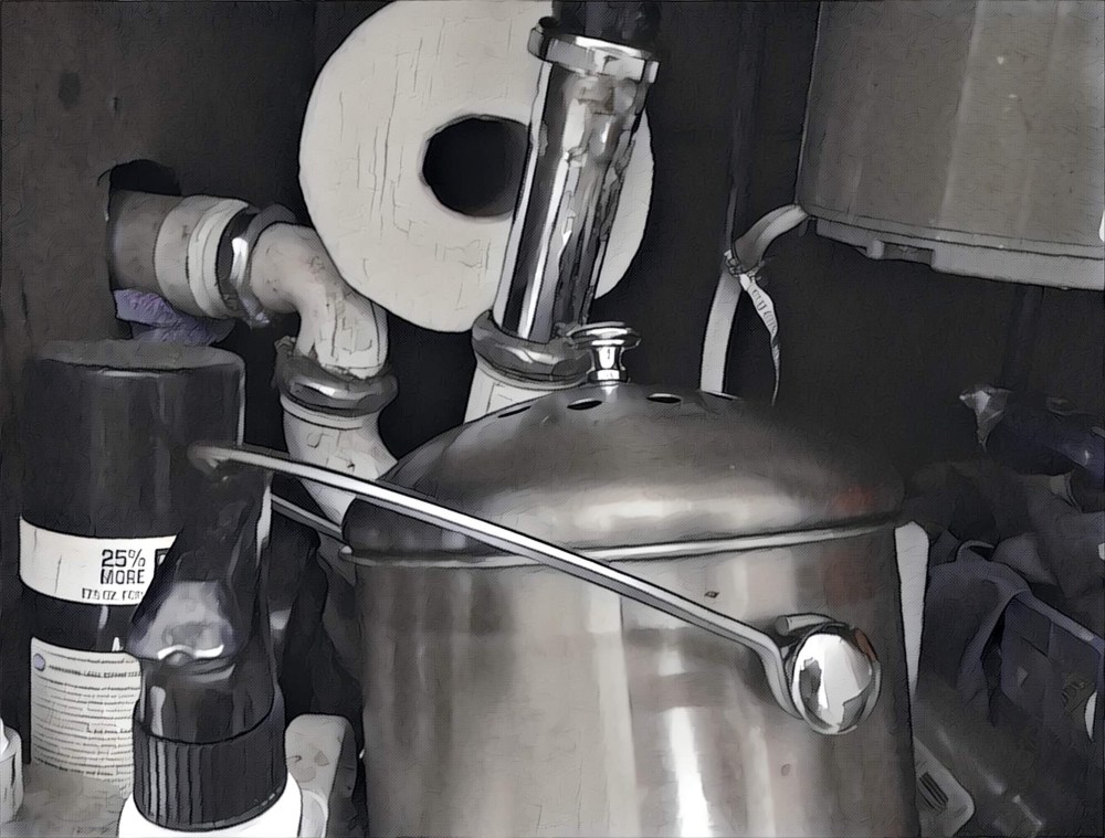 Underneath the sink. There's some pipes and a spare paper towel roll and the compost bin. It's a bit dark. 