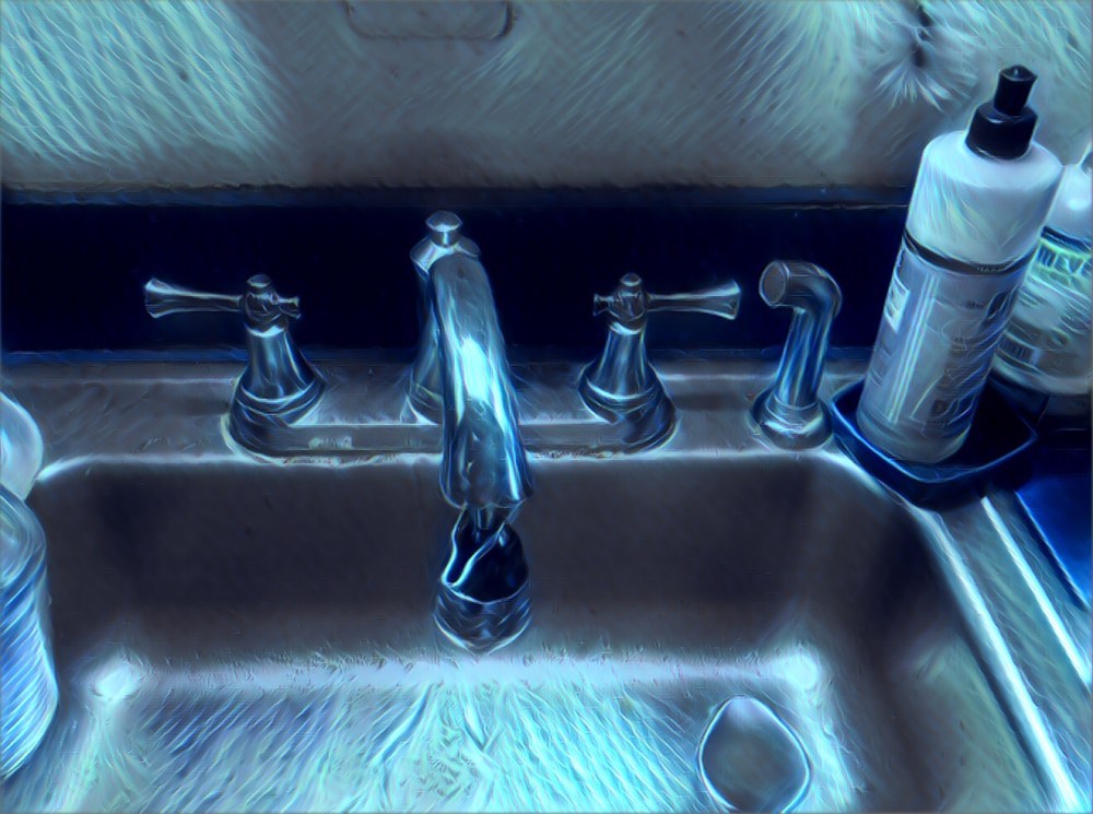 An old sink and faucet with an electric blue cast. 