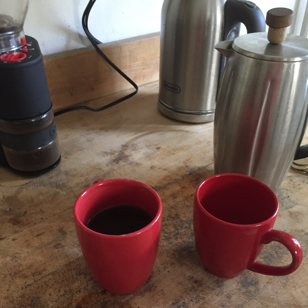 Two red mugs and a coffee setup.