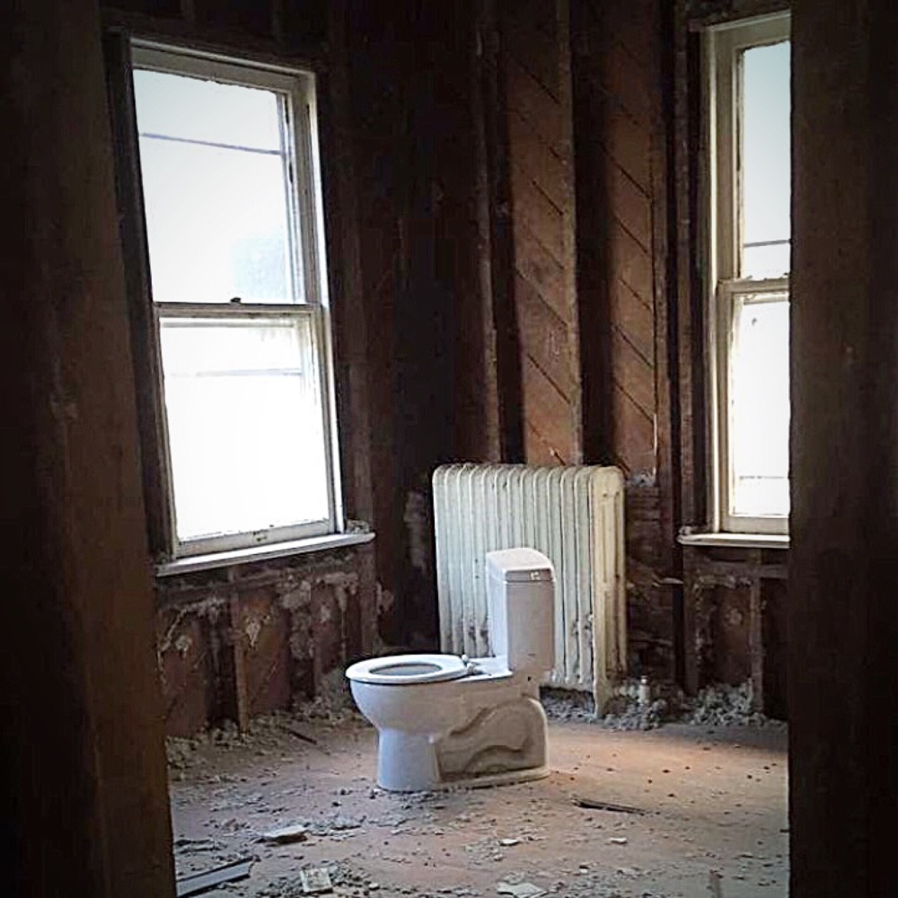 The toilet has been excavated and moved into the Big Guy's bedroom. And there's no plaster left on the walls.